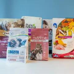 Flera påsar kattmat, inklusive mjukt torrfoder katt, med bilder på katter och frukter.