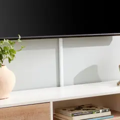 Snygg inredning tv-möbel med en vas, en guldig skulptur och böcker. Kabellisten ger ett rent intryck.