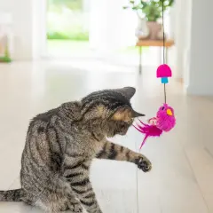 En randig katt leker med en rosa fågelleksak som hänger i ett snöre. Perfekt för att aktivera innekatt och hålla den sysselsatt.