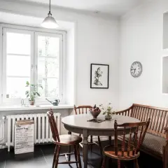 Mysig köksvrå med runt matbord, träbänk och stolar. Perfekt för runt matbord inspiration.