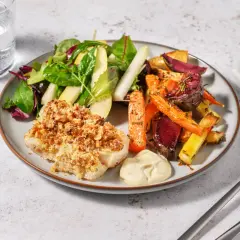 En tallrik med nötpanerad fisk, ugnsrostade rotfrukter och en fräsch sallad. Perfekt kummel temperatur för en härlig måltid.