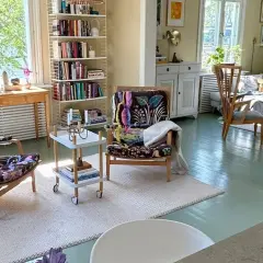 Ljust och luftigt vardagsrum med två färgstarka fåtöljer, bokhyllor och en soffgrupp. En harmonisk känsla som påminner om feng shui vardagsrum.