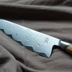 En vackert mönstrad kockkniv med damaskusstål, ett riktigt mästerverk och den bästa kniven för köket.