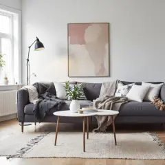 En mysig soffa med bohemisk inredning, kuddar, plädar och en abstrakt tavla.