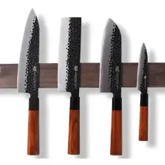 Fyra japanska knivar med hamrad yta och trähandtag, monterade på en magnetisk trälist. En samling som representerar den bästa japanska kniven för ditt kök.