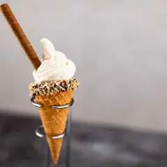 Mjukglass i strut med nötter och en chokladpinne. En härlig sommardessert som visar vad innehåller mjukglass.