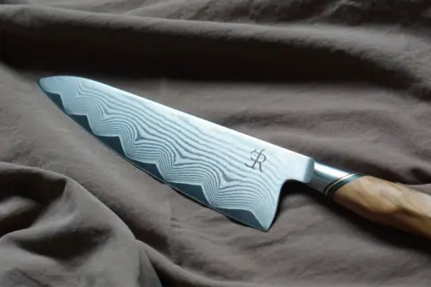 En vackert mönstrad kockkniv med damaskusstål, ett riktigt mästerverk och den bästa kniven för köket.
