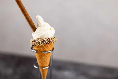 Mjukglass i strut med nötter och en chokladpinne. En härlig sommardessert som visar vad innehåller mjukglass.