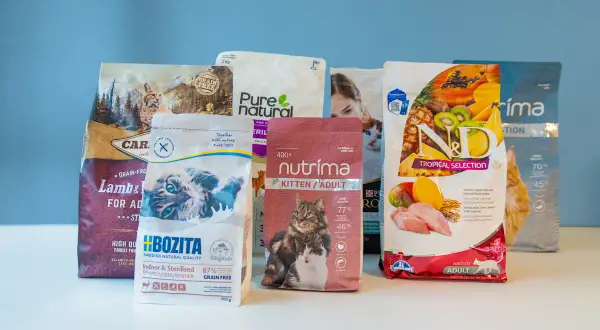 Flera påsar kattmat, inklusive mjukt torrfoder katt, med bilder på katter och frukter.