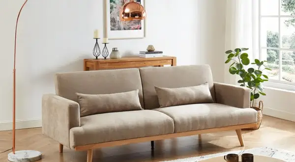 En ljus och luftig salong med soffa, soffbord och golvlampa i klassisk nordisk design.