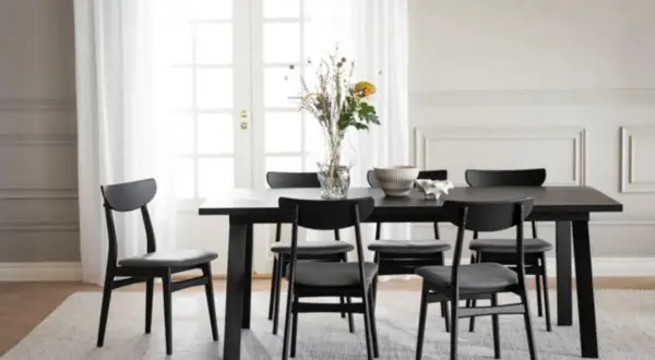 Svart matbord med sex stolar, en vas med blommor och en skål. Perfekt inspiration dekoration matbord för ett modernt hem.