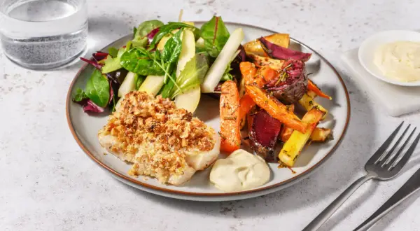 En tallrik med nötpanerad fisk, ugnsrostade rotfrukter och en fräsch sallad. Perfekt kummel temperatur för en härlig måltid.