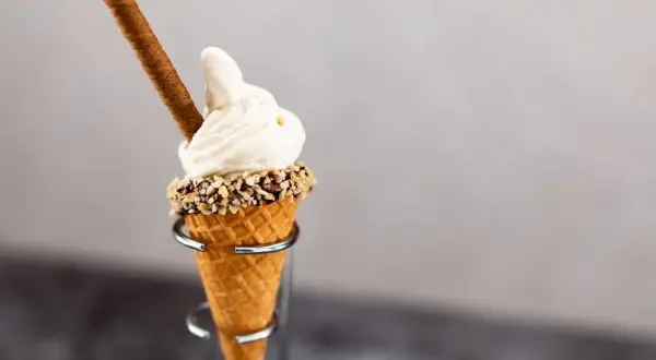 Mjukglass i strut med nötter och en chokladpinne. En härlig sommardessert som visar vad innehåller mjukglass.