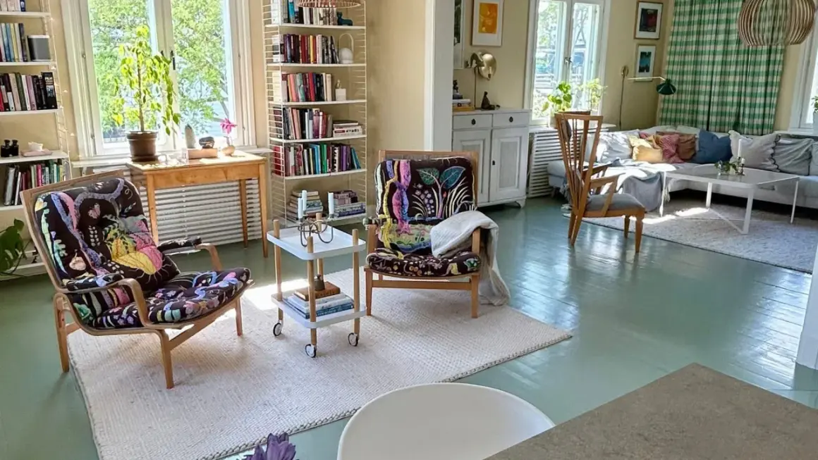 Ljust och luftigt vardagsrum med två färgstarka fåtöljer, bokhyllor och en soffgrupp. En harmonisk känsla som påminner om feng shui vardagsrum.