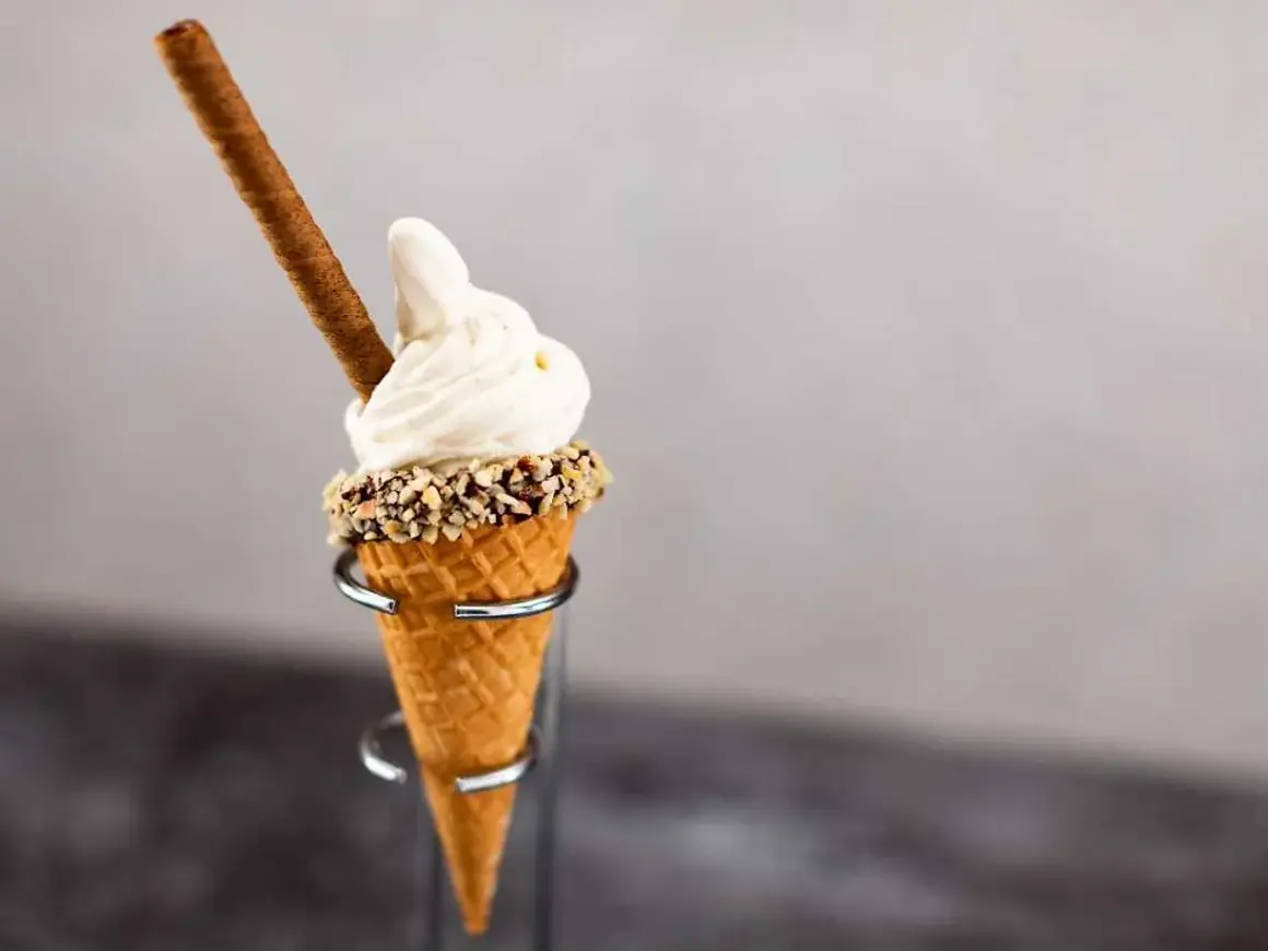 Mjukglass i strut med nötter och en chokladpinne. En härlig sommardessert som visar vad innehåller mjukglass.