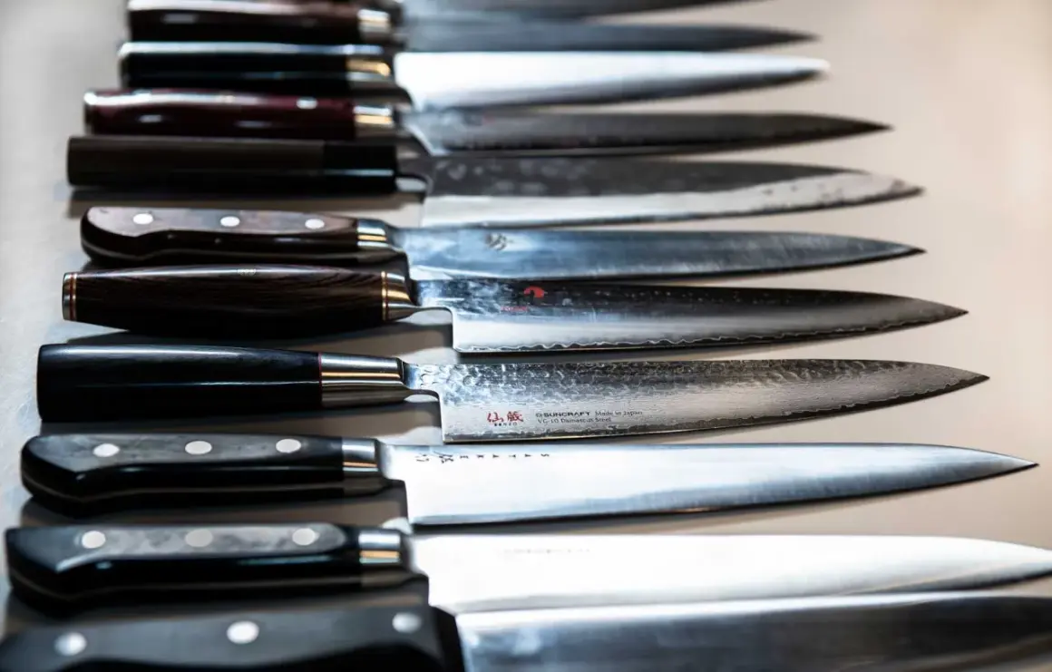 En rad vassa kockknivar, redo för ett kockkniv test. Vackra handtag i trä och metall, med blanka blad.