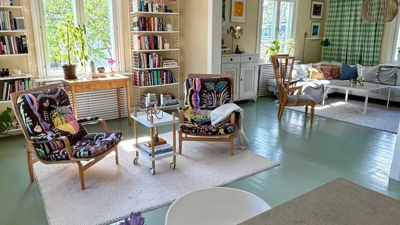 Ljust och inbjudande vardagsrum med två färgstarka fåtöljer, bokhyllor och en soffgrupp. En känsla av harmoni och lugn som passar bra för feng shui vardagsrum.