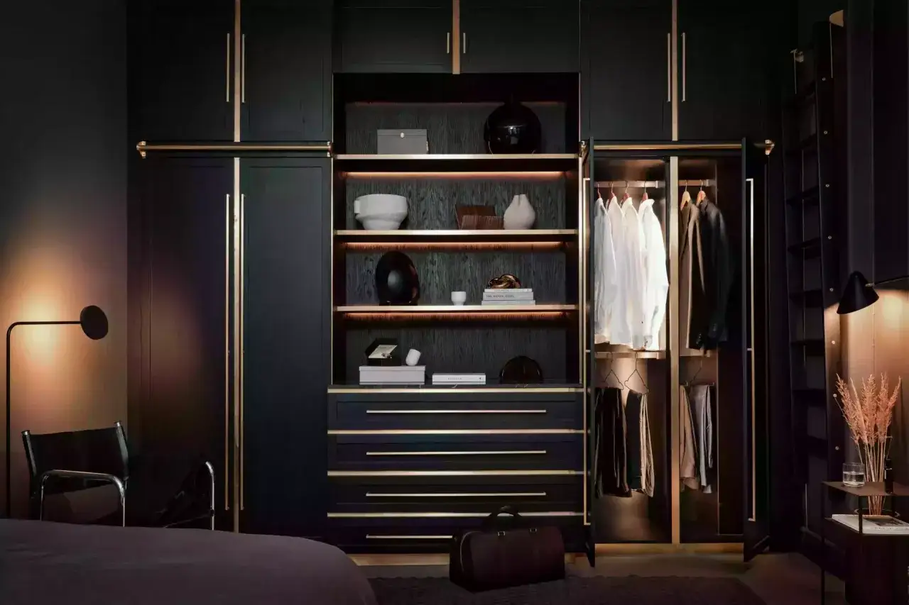 Mörk, lyxig garderob med gulddetaljer. Perfekt inspiration garderob för att organisera skjortor, kostymer och accessoarer.