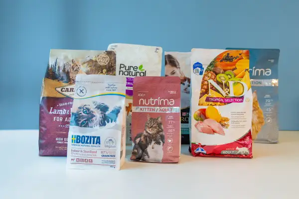 Flera påsar kattmat, inklusive mjukt torrfoder katt, med bilder på katter och frukter.