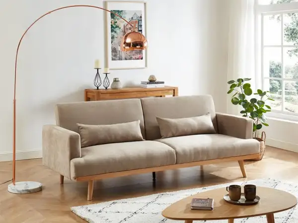 En ljus och luftig salong med soffa, soffbord och golvlampa i klassisk nordisk design.
