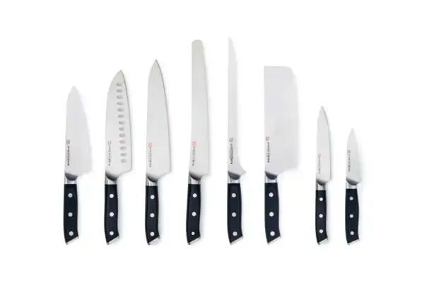 En samling knivar, ett knivset bäst i test, med svarta handtag och blanka blad i olika storlekar och former.